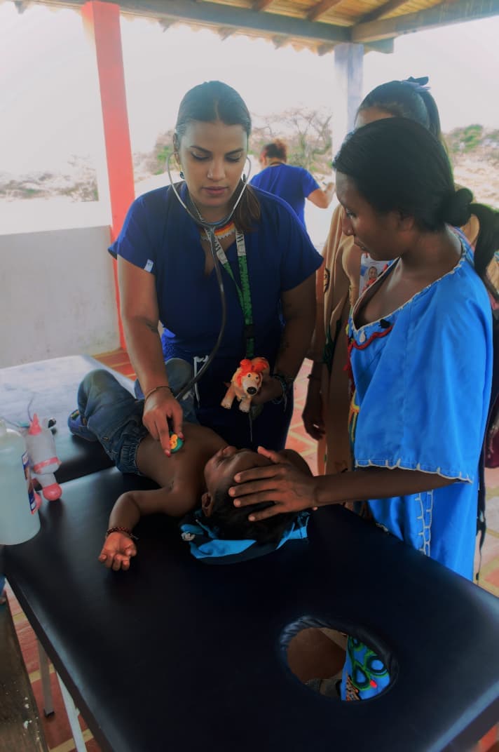 Médica examinando a un bebé de comunidad indígena