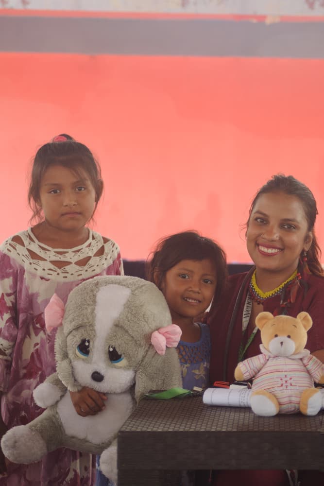 Niños indígenas recibiendo juguetes de voluntaria